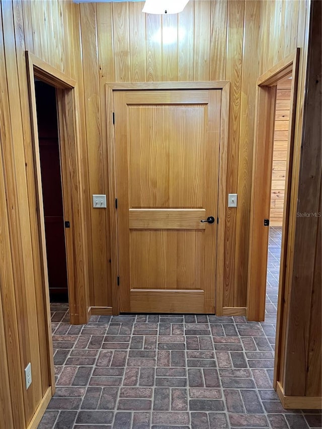 doorway to outside featuring wood walls