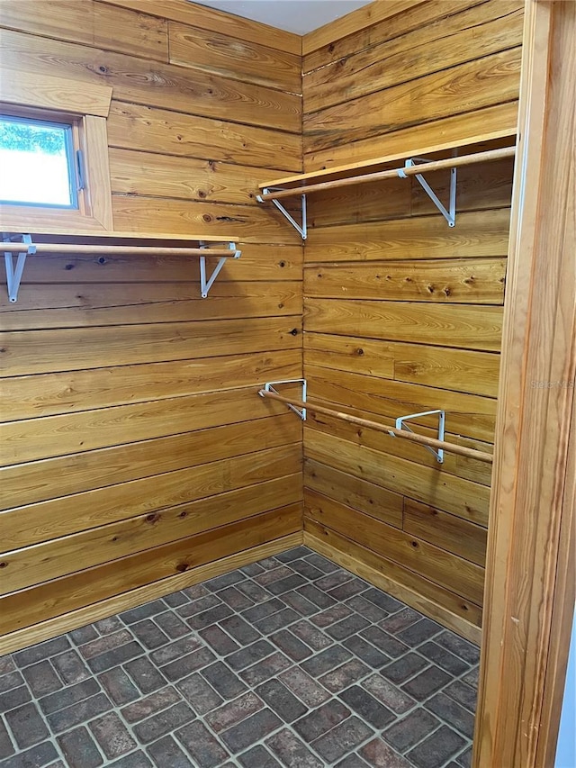 clothes washing area with wood walls