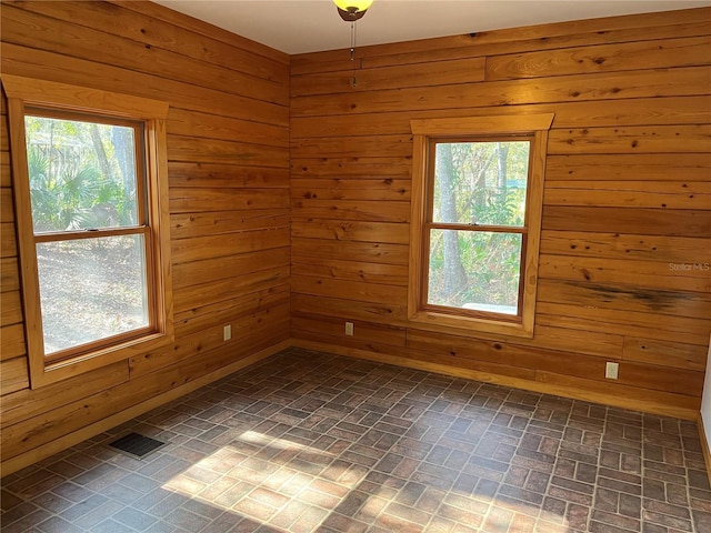 unfurnished room with wooden walls