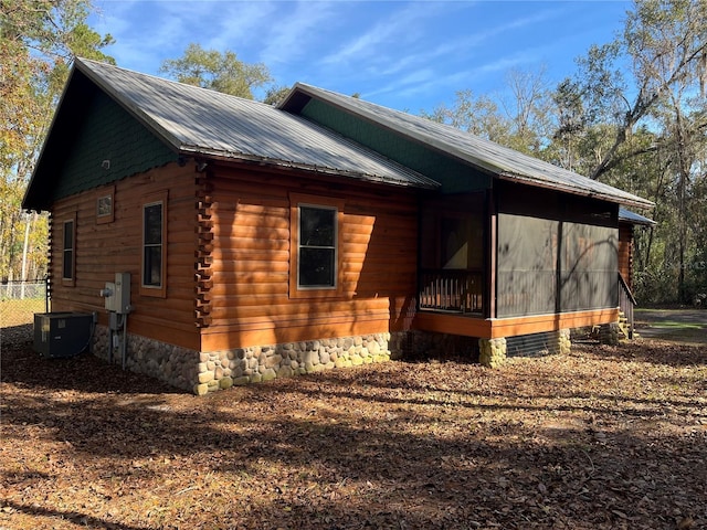 view of property exterior featuring a sunroom and central air condition unit