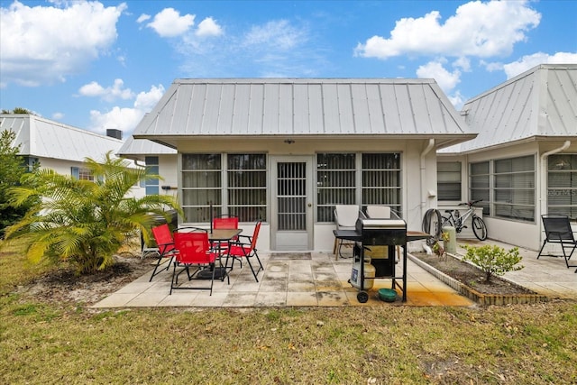 back of property with a patio area and a lawn