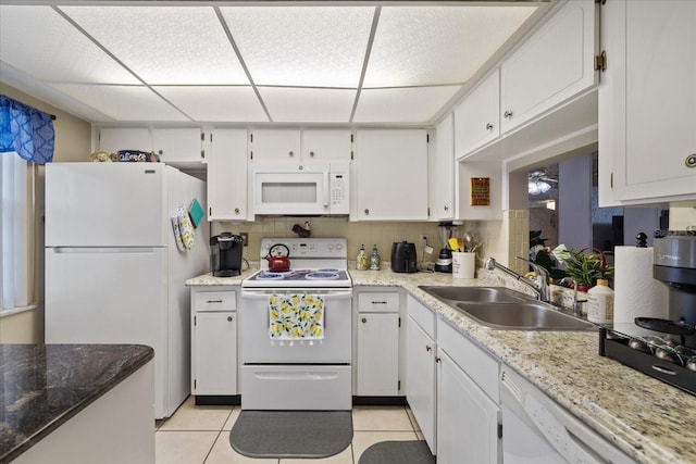 kitchen with white appliances, sink, white cabinetry, light tile patterned flooring, and tasteful backsplash