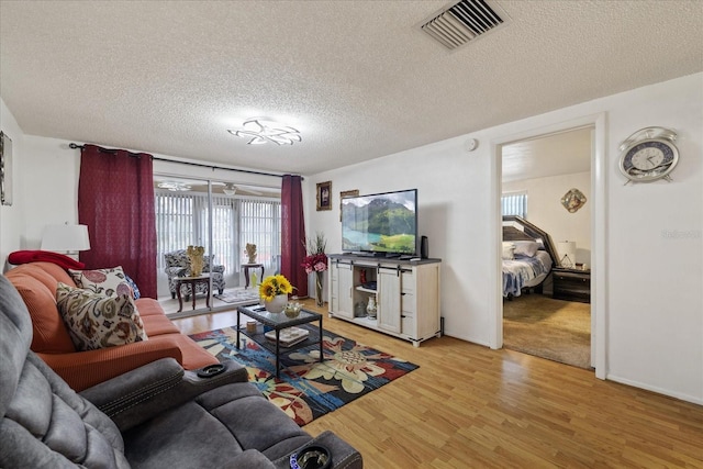 living room featuring a textured ceiling and light hardwood / wood-style floors