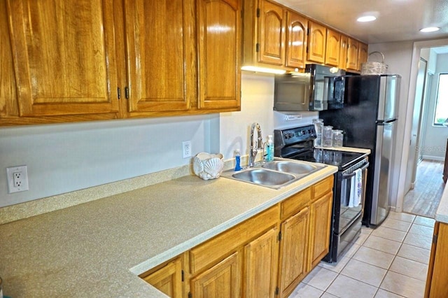 kitchen featuring light tile patterned floors, sink, and black appliances