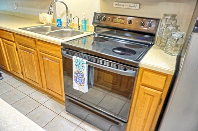 kitchen featuring light tile patterned flooring, black range with electric cooktop, and sink