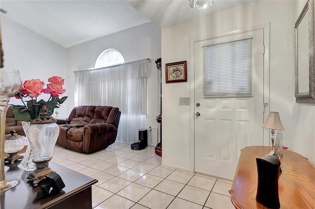 tiled foyer entrance featuring a textured ceiling