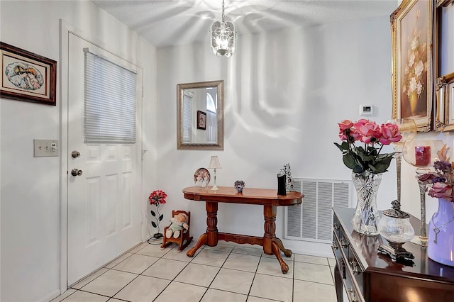 foyer entrance featuring light tile patterned floors and a textured ceiling