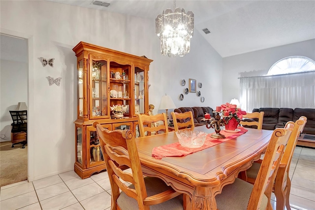 tiled dining area with a chandelier and vaulted ceiling