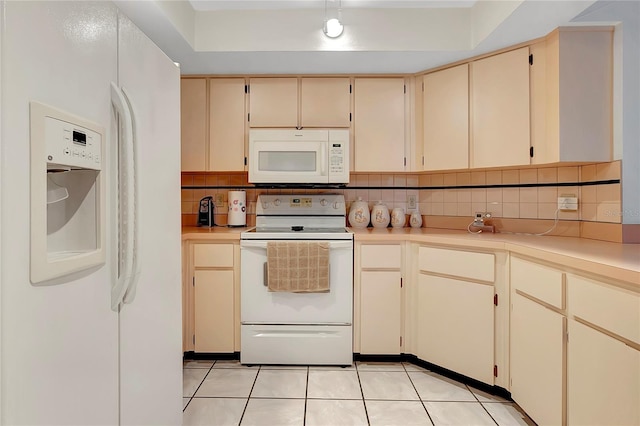 kitchen with decorative backsplash, light tile patterned floors, white appliances, and cream cabinetry