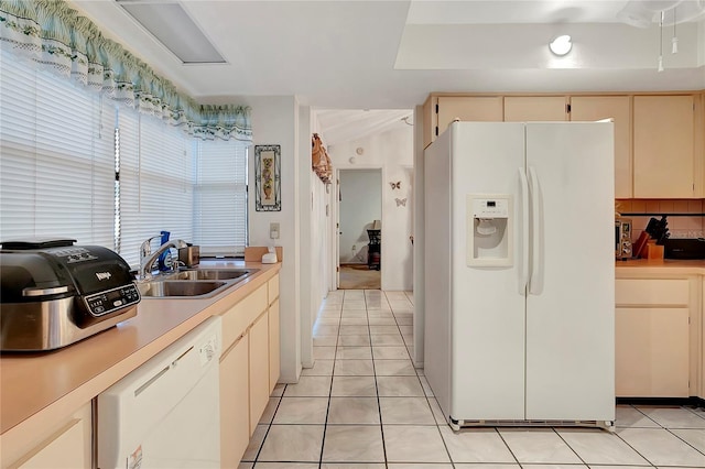 kitchen with cream cabinets, sink, light tile patterned floors, and white appliances