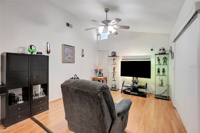 living room with ceiling fan, light hardwood / wood-style floors, and high vaulted ceiling