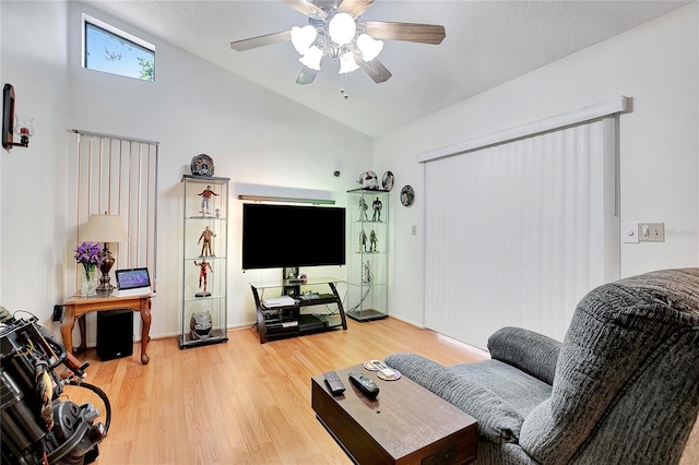 living room with hardwood / wood-style floors, ceiling fan, and lofted ceiling