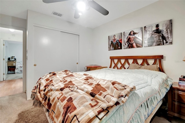 carpeted bedroom with ceiling fan and a closet