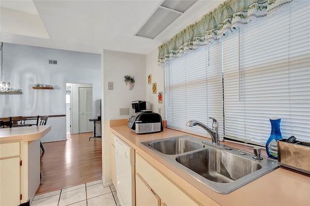 kitchen with white dishwasher, light tile patterned flooring, and sink