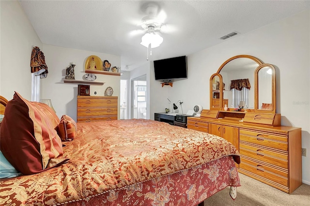 carpeted bedroom featuring ceiling fan and a textured ceiling