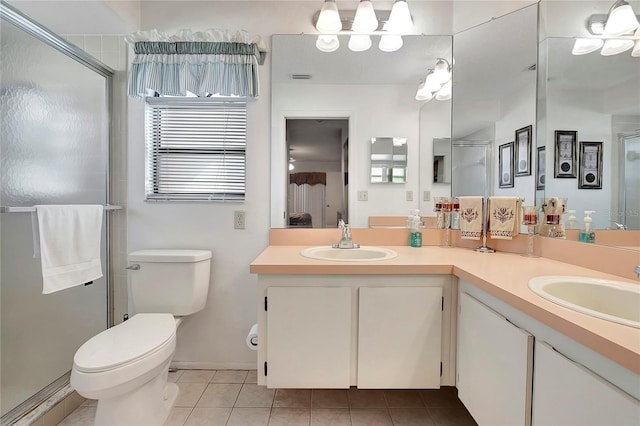 bathroom with tile patterned floors, vanity, toilet, and a shower with shower door