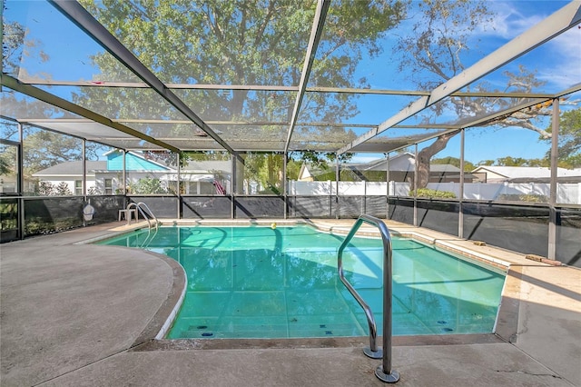 view of swimming pool featuring glass enclosure and a patio