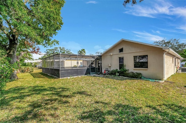 back of property with a lanai and a lawn