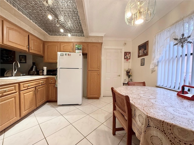 kitchen featuring sink, white fridge, a chandelier, decorative light fixtures, and ornamental molding