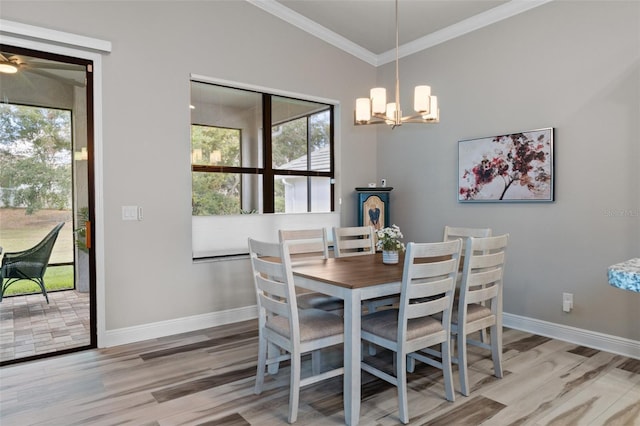 dining space featuring lofted ceiling, light wood-type flooring, an inviting chandelier, and ornamental molding