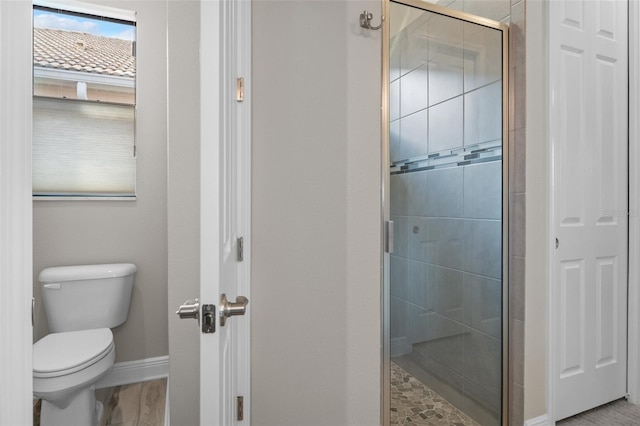 bathroom featuring toilet and an enclosed shower