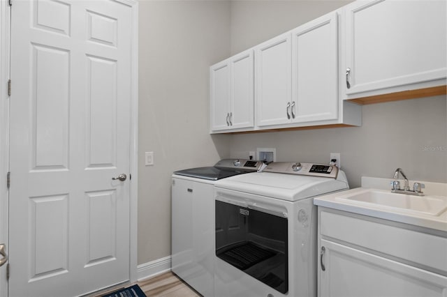 washroom with sink, cabinets, light wood-type flooring, and independent washer and dryer