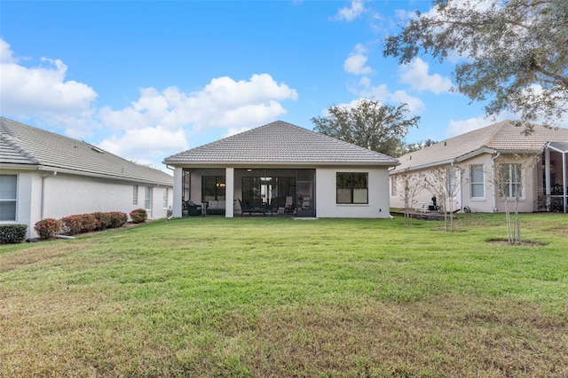 rear view of property with a sunroom and a yard