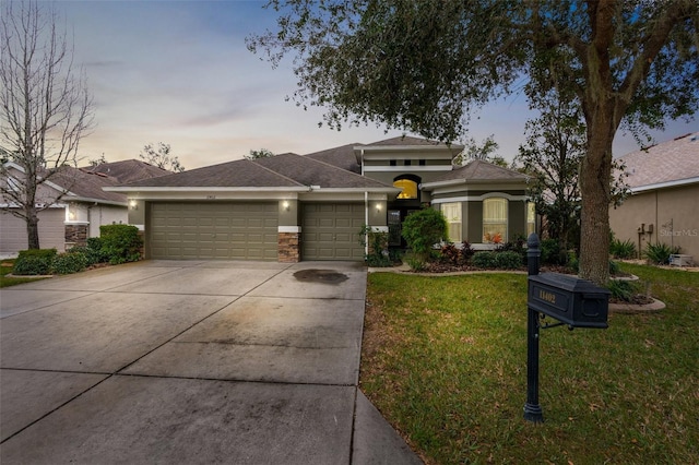 view of front of property with a garage and a yard