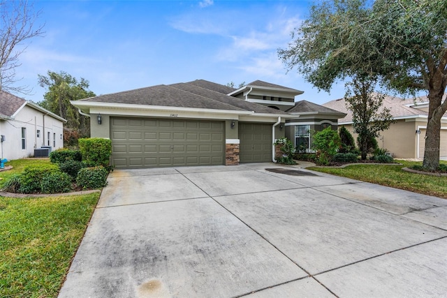 view of front of home with a front yard, a garage, and cooling unit