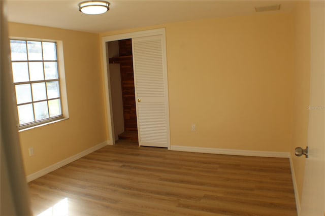 unfurnished bedroom with hardwood / wood-style floors and a closet