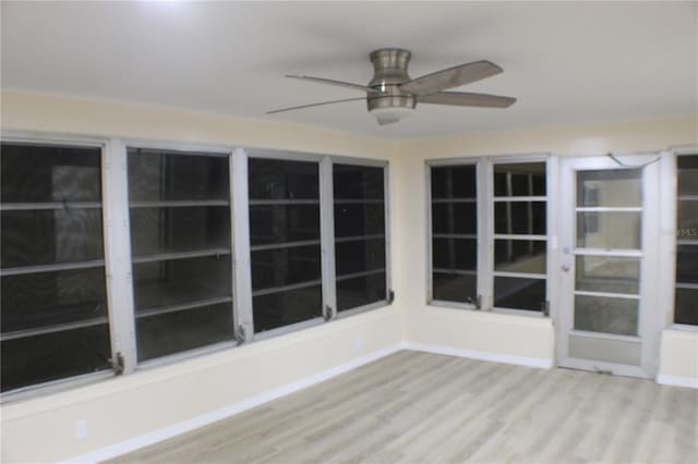 unfurnished sunroom featuring ceiling fan