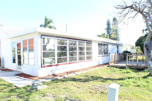 rear view of house with a yard and a wooden deck