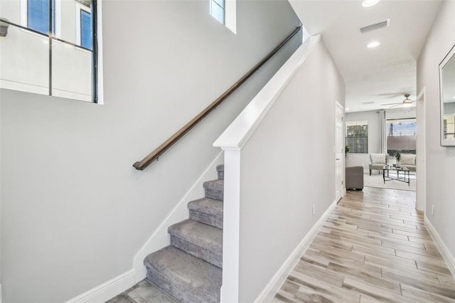 stairs featuring ceiling fan