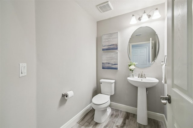 bathroom with hardwood / wood-style floors, a textured ceiling, and toilet