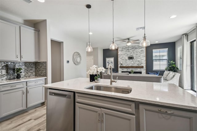 kitchen featuring dishwasher, backsplash, sink, hanging light fixtures, and gray cabinets