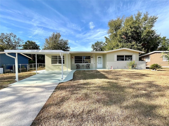 ranch-style home with a front lawn, a porch, and a carport