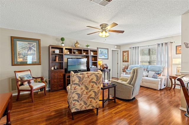 living room with hardwood / wood-style floors, ceiling fan, and a textured ceiling