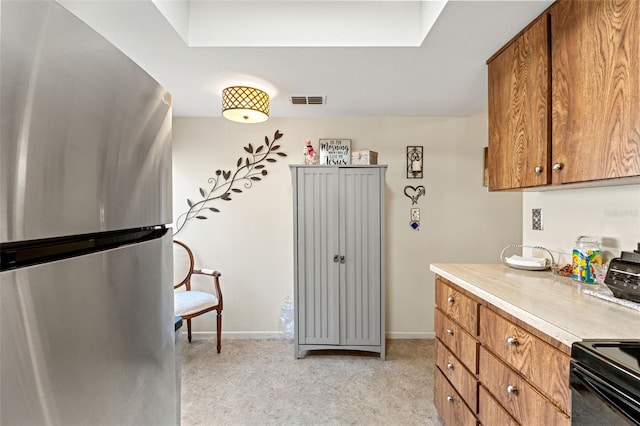 kitchen featuring black electric range and stainless steel fridge