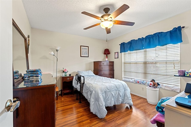 bedroom featuring wood-type flooring, a textured ceiling, and ceiling fan