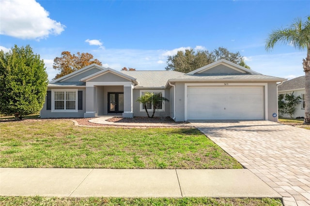 ranch-style home with a garage and a front lawn