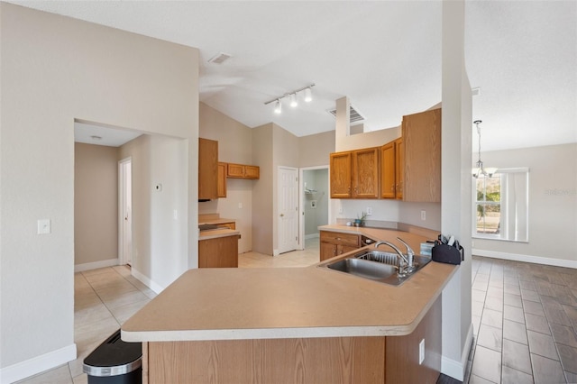 kitchen featuring lofted ceiling, light tile patterned flooring, kitchen peninsula, and sink