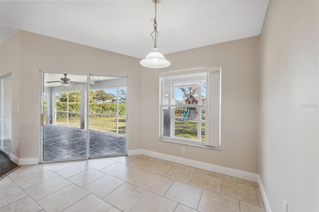 unfurnished dining area with light tile patterned floors, a textured ceiling, and ceiling fan