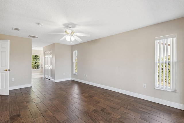 spare room featuring ceiling fan, dark hardwood / wood-style flooring, and a textured ceiling