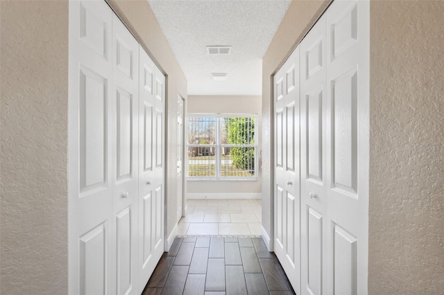 hallway with a textured ceiling