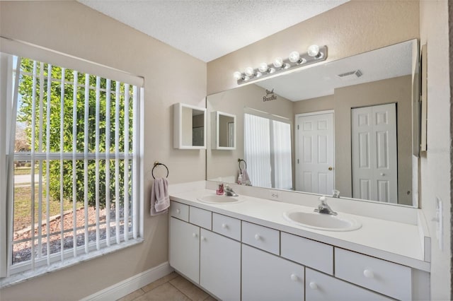 bathroom with tile patterned floors, vanity, and a textured ceiling