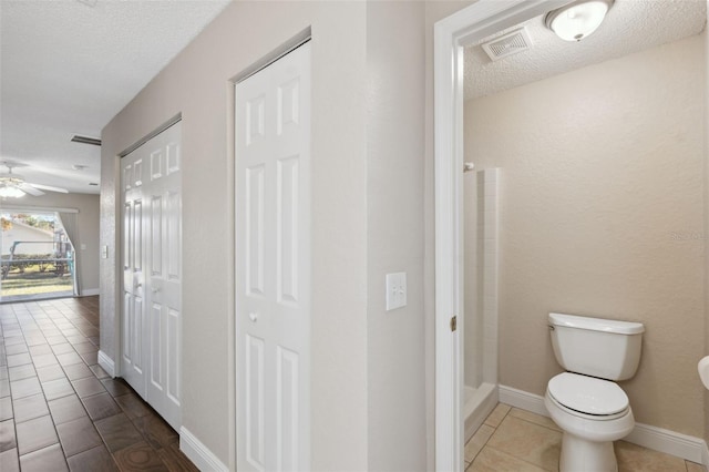 hall featuring tile patterned floors and a textured ceiling