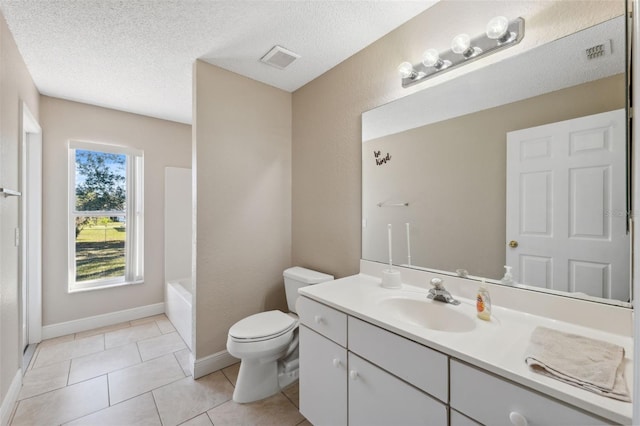 bathroom with tile patterned floors, vanity, a textured ceiling, and toilet