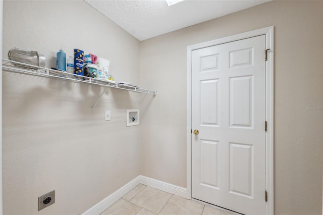 clothes washing area with washer hookup, electric dryer hookup, light tile patterned floors, and a textured ceiling