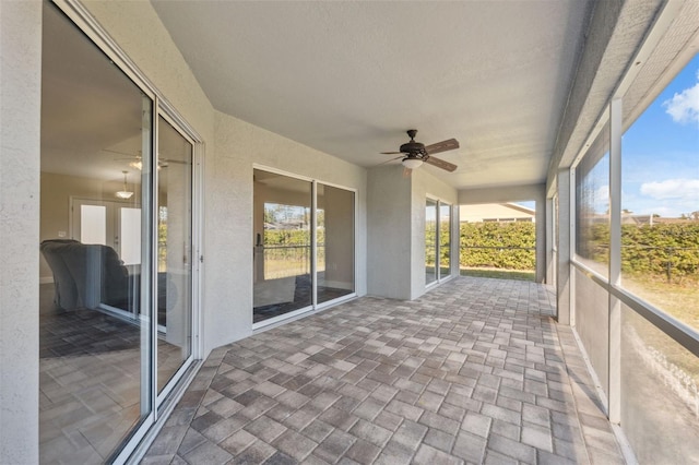 unfurnished sunroom with ceiling fan