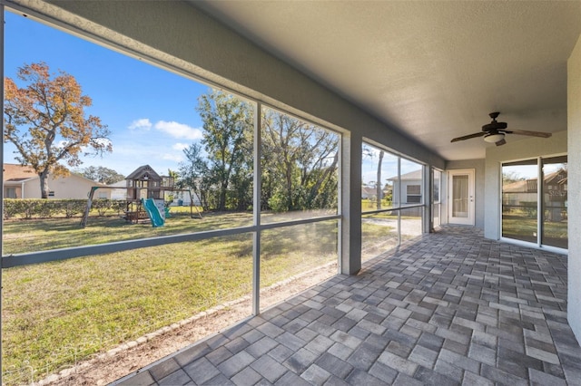 unfurnished sunroom featuring ceiling fan